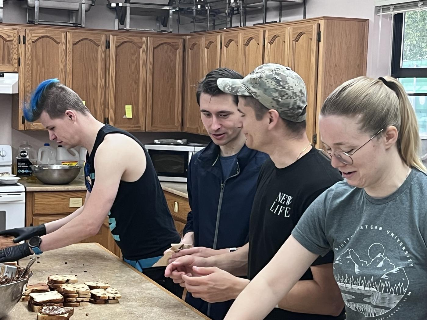 Young volunteers making sandwiches in a church kitchen
