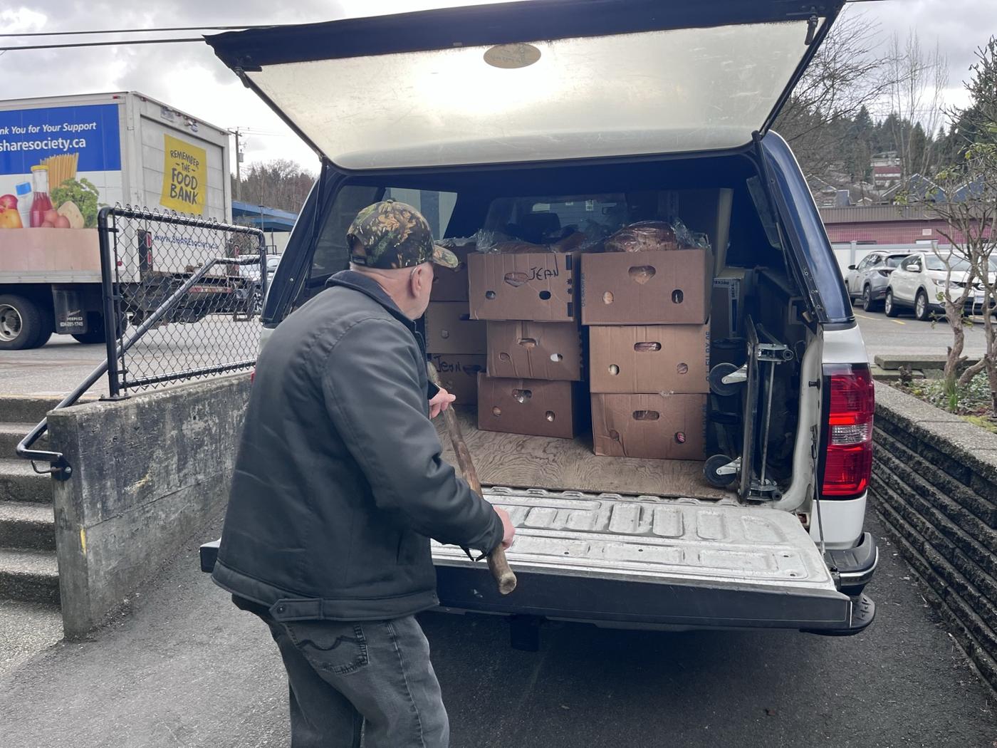 A volunteer loading boxes of donations into a pickup truck